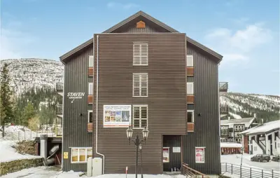 a building in the snow in front of a mountain at Gorgeous Apartment In Hemsedal in Hemsedal