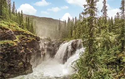 a waterfall in the middle of a forest at Gorgeous Apartment In Hemsedal in Hemsedal