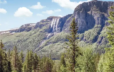 a mountain with a waterfall and trees in the foreground at Gorgeous Apartment In Hemsedal in Hemsedal