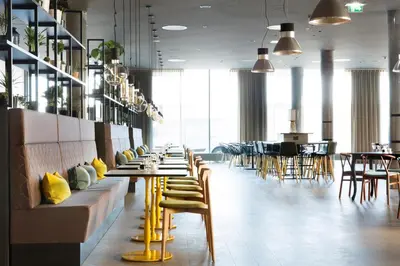 a restaurant with yellow chairs and tables and tablesktop at Comfort Hotel Bergen Airport in Bergen