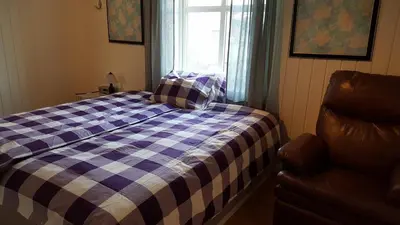 a bedroom with a bed and a window and a chair at Egil's Vacation House in Lillehammer
