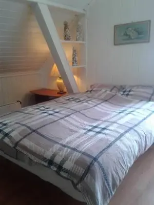 a bed with a striped blanket in a bedroom at Egil's Vacation House in Lillehammer