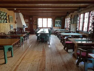 a dining room with tables and chairs and windows at Dovregubbens Hall in Vålåsjø