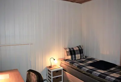 a bedroom with a bed and a table with a lamp at Løvheim Gjestehus - Anneks in Sauland
