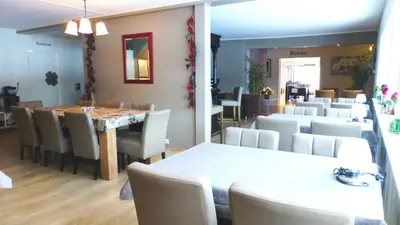 a dining room with a table and white chairs at Løvheim Gjestehus - Anneks in Sauland