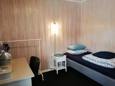a small room with a bed and a table and a lamp at Løvheim Gjestehus - Anneks in Sauland