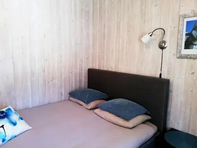 a room with a bed with two pillows and a lamp at Løvheim Gjestehus - Anneks in Sauland