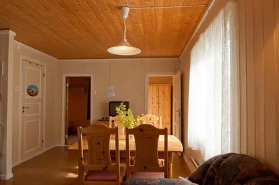 a dining room with a table and chairs and a ceiling at Magalaupe Camping in Oppdal