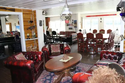 a living room with leather chairs and a table at Gamlestølen Fjellstue in Etnedal