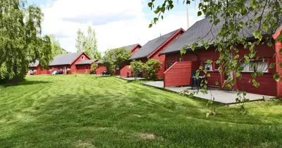 a group of red barns with a grass yard at Jorekstad Ferieleiligheter in Fåberg