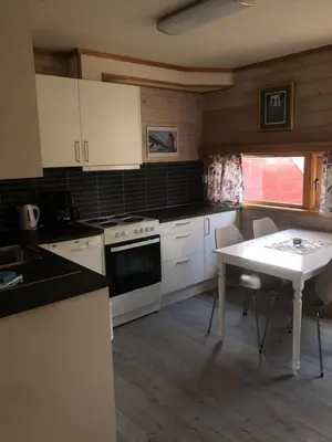 a kitchen with white appliances and a white table at Jorekstad Ferieleiligheter in Fåberg