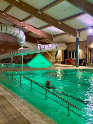 a person swimming in a pool with a water slide at Jorekstad Ferieleiligheter in Fåberg