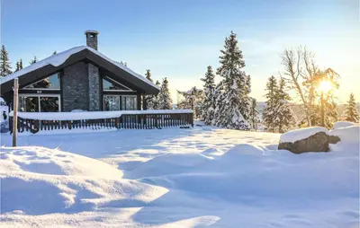 a house covered in snow with the sun in the background at Sjusjøen-Pihl 89 in Sjusjøen