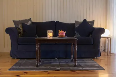 a blue couch with a table in a living room at Kylstad Bed and Breakfast in Kylstad