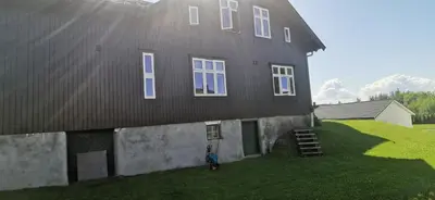 a person standing in front of a black house at Kylstad Bed and Breakfast in Kylstad