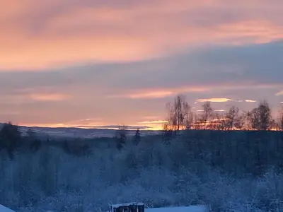 a bench sitting in a field at sunset at Kylstad Bed and Breakfast in Kylstad