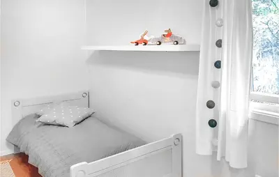 a small white bedroom with a bed and a shelf at Three-Bedroom Holiday Home In Vikanes in Eiknes