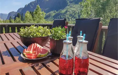 a table with two bottles of soda and a plate of fruit at Three-Bedroom Holiday Home In Vikanes in Eiknes