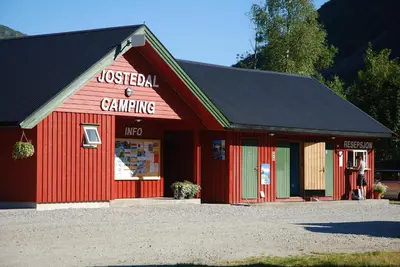 a red barn with a sign that readsractical camping at Jostedal Camping in Jostedal