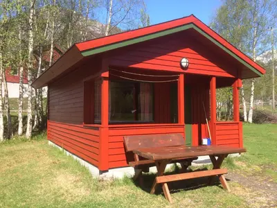 a smallshed with a picnic table in the grass at Jostedal Camping in Jostedal