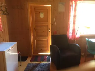 a living room with a door and a chair at Jostedal Camping in Jostedal