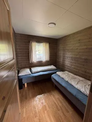 a small room with two beds and a window at Skottneset Feriesenter in Barmen