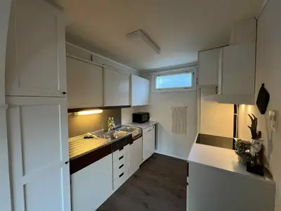a white kitchen with white cabinets and a sink at Fonnagata in Åndalsnes