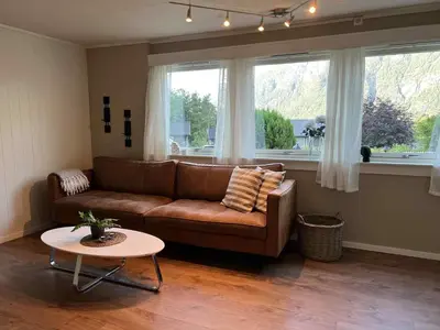 a living room with a brown couch and a table at Fonnagata in Åndalsnes