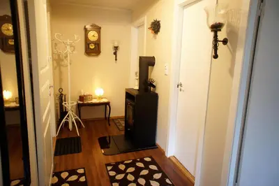 a hallway with a television and a clock on the wall at Berge & Laila's Private Apartment in Førde