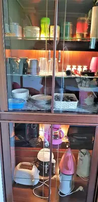 a cabinet filled with lots of dishes and appliances at Berge & Laila's Private Apartment in Førde