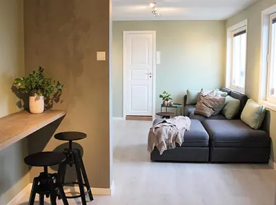 a living room with a couch and two bar stools at City View Studio Apartment in Ålesund