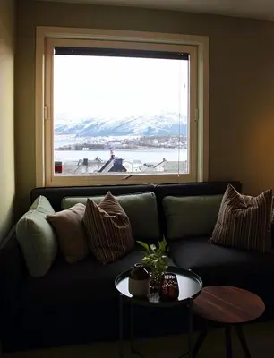 a living room with a couch and a large window at City View Studio Apartment in Ålesund