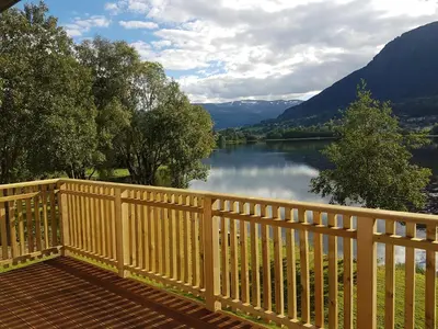 a wooden deck with a view of a lake at Voss Interlake - Villa in Skulestadmo
