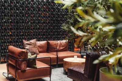 a room with two leather chairs and a wall of wine bottles at Magic Kloverhuset Harbour Hotel, a member of Radisson Individuals in Bergen