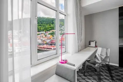a desk with a pink lamp in a room with a window at Magic Kloverhuset Harbour Hotel, a member of Radisson Individuals in Bergen