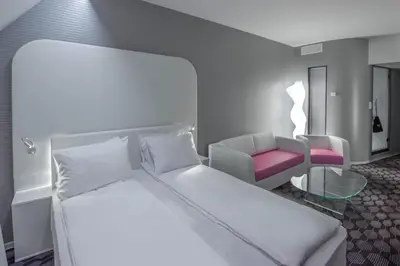 a hotel room with a bed and a chair at Magic Kloverhuset Harbour Hotel, a member of Radisson Individuals in Bergen