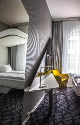 a hotel room with a bed and a table and a yellow chair at Magic Hotel Bergen City Center, a member of Radisson Individuals in Bergen