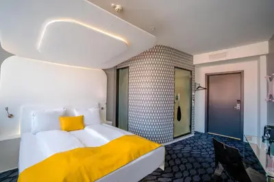 a bedroom with a large bed with a yellow pillow at Magic Hotel Bergen City Center, a member of Radisson Individuals in Bergen