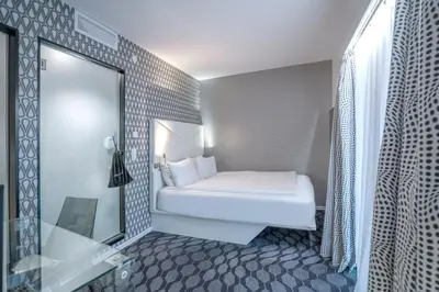 a bedroom with a white bed and a mirror at Magic Hotel Bergen City Center, a member of Radisson Individuals in Bergen