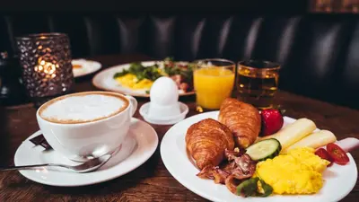 a table topped with plates of food and a cup of coffee at Magic Hotel Bergen City Center, a member of Radisson Individuals in Bergen