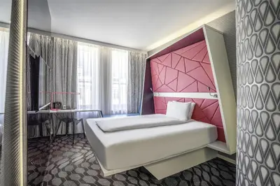 a bedroom with a white bed and a pink headboard at Prize by Radisson, Xhibition Bergen City in Bergen