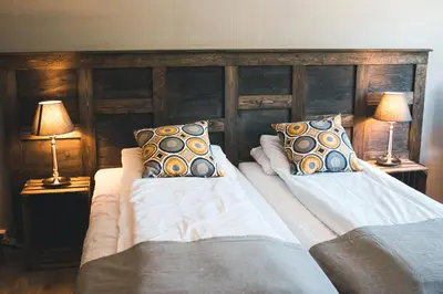 two beds in a bedroom with two lamps at Veggli Vertshus in Veggli