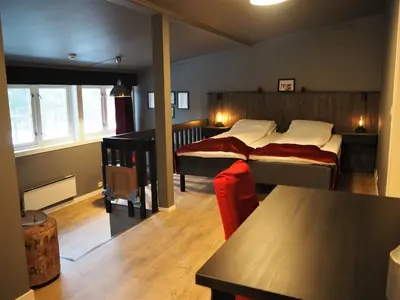 a bedroom with two beds and a table in it at Veggli Vertshus in Veggli