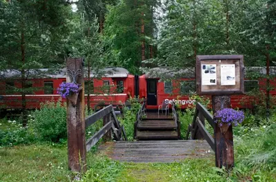 a red train traveling down a wooden bridge with flowers at Veggli Vertshus in Veggli