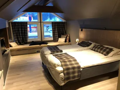 a bedroom with two beds and a couch and windows at Veggli Vertshus in Veggli