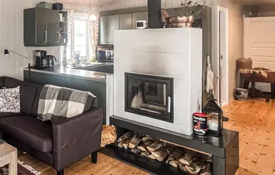 a living room with a fireplace and a couch at Amazing Home In Kvam With Kitchen in Kvam