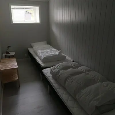 two twin beds in a room with a window at Mørkve Apartement in Myrkdalen