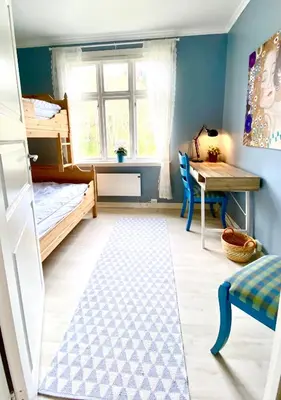 a bedroom with a bunk bed and a desk and a table at Fjord View Apartment in Stranda