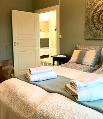 two beds in a room with towels on them at Fjord View Apartment in Stranda