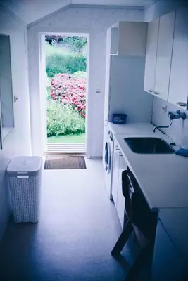 a kitchen with a sink and a door to a yard at Dalhus - House with jacuzzi in Norddal